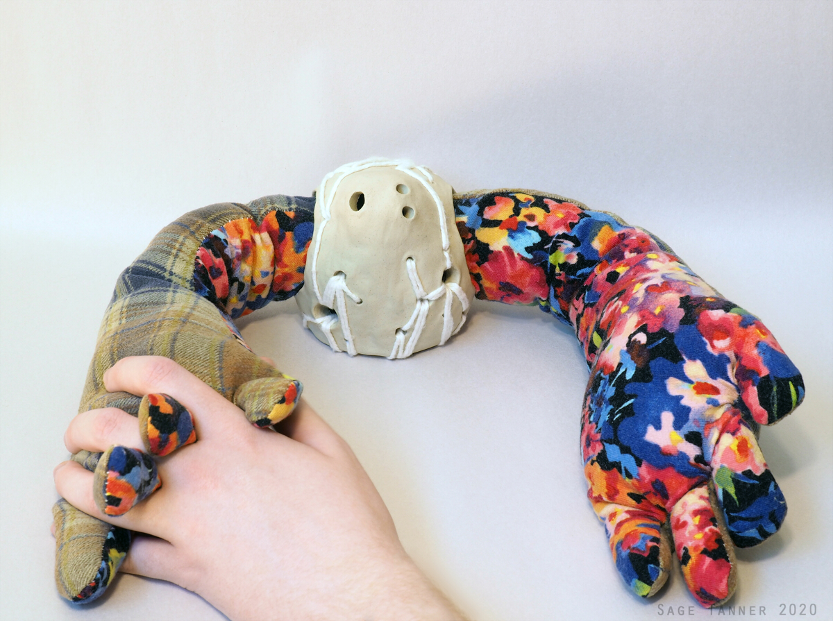 A doll with a white ceramic body and oversized fabric arms.